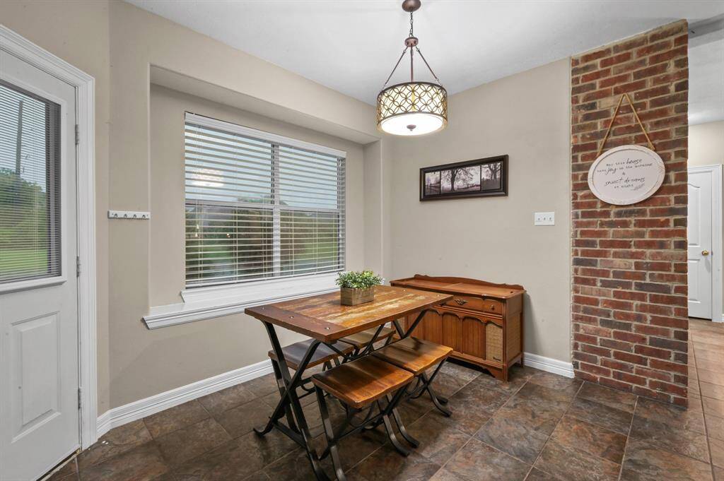 Another view of the breakfast room with access to the backyard and detached garage.  Love the charm of the brick wall accent