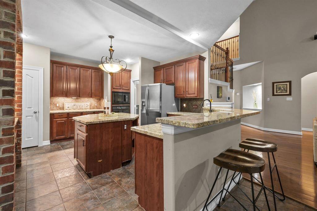 The kitchen with easy to care for tile flooring and granite counters with center island.