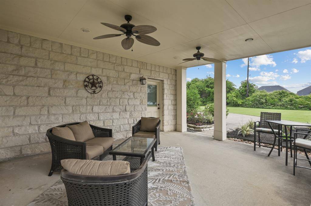 Tucked behind the front shrubs is a cozy outdoor sitting area to enjoy morning coffee or an afternoon ice tea.  Complete with 2 fans and outdoor furniture that will stay