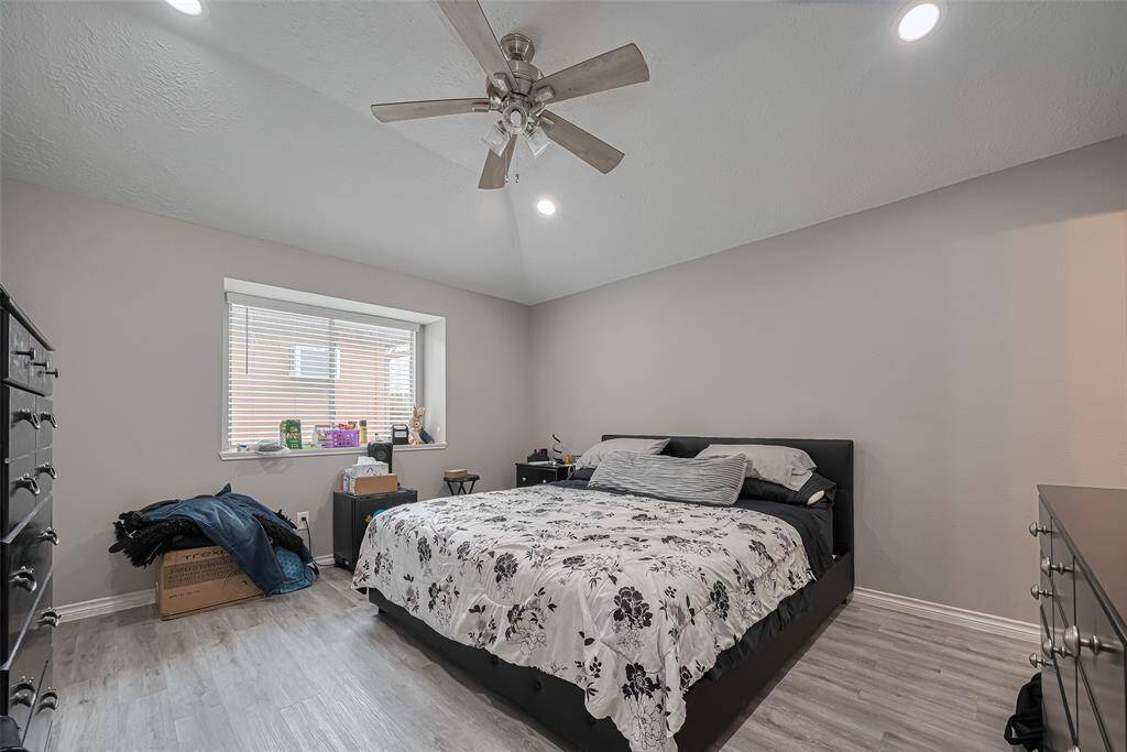 Huge primary bedroom boasts so many attributes; double window with deep ledge, recessed lighting, high ceiling, ceiling fan, decorator paint & luxury plank vinyl flooring