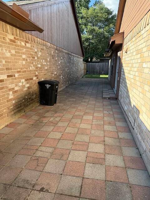 Paver patio runs from front gate to back corner of home