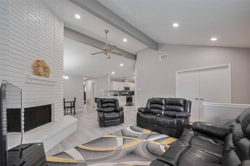 Another view of the living area flowing into dining room and a peek into the stunning kitchen.