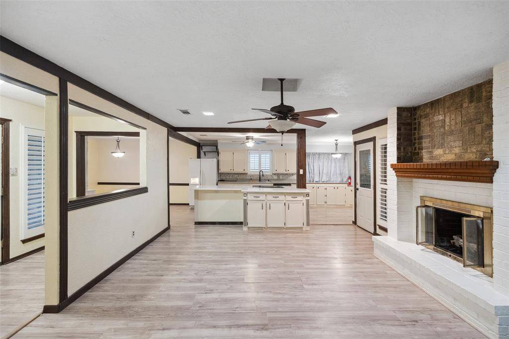 Notice the wooden accents and kitchen island with storage and bar.