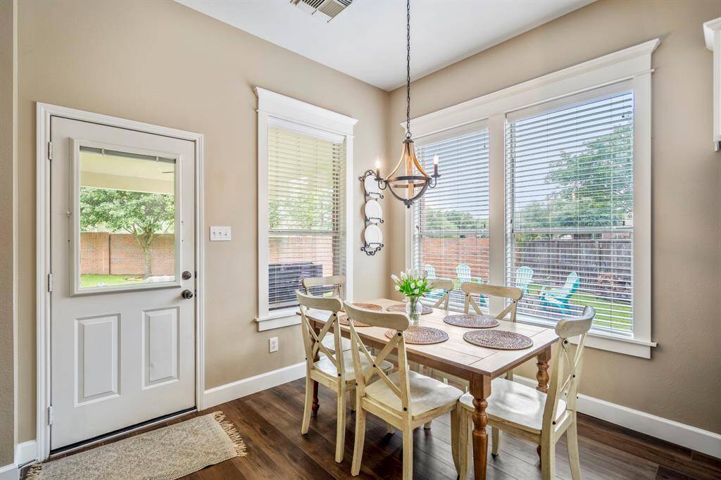 The corner breakfast room offers natural tones, beautiful upgraded lighting, luxury crown moldings, and a door to the covered patio.