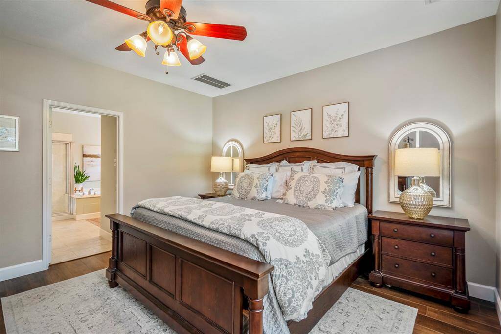 With neutral wall color inspired by nature, this primary bedroom offers a luxurious retreat for the owner of the home with an en-suite bathroom.