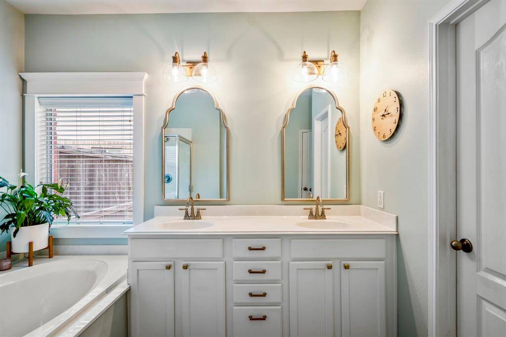 Enjoy a spa-like luxurious bathroom, in a calming color palette; featuring decorator-styled lighting, dual mirrors and ample storage.