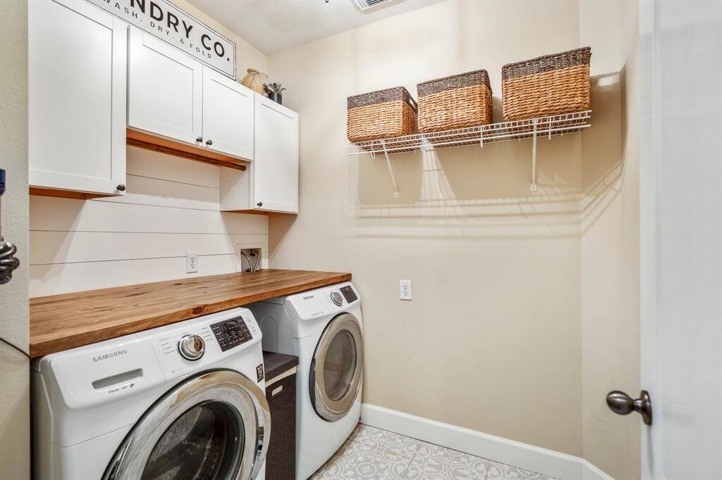 Even the laundry of this home is elevated, with beautiful upgraded tiled flooring, a wooden folding shelf and custom cabinetry.