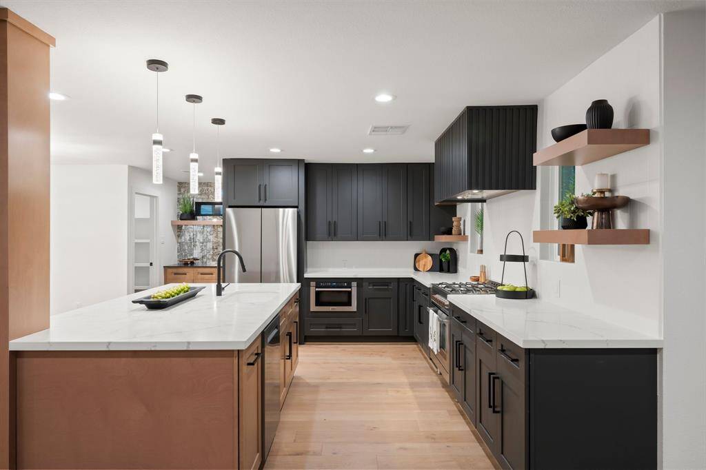 This kitchen should be in a magazine! The fine frameless custom cabinetry in contrasting colors is over the top in design, fit and finishes. Topped with stunning white quartz counters and stainless steel appliances.