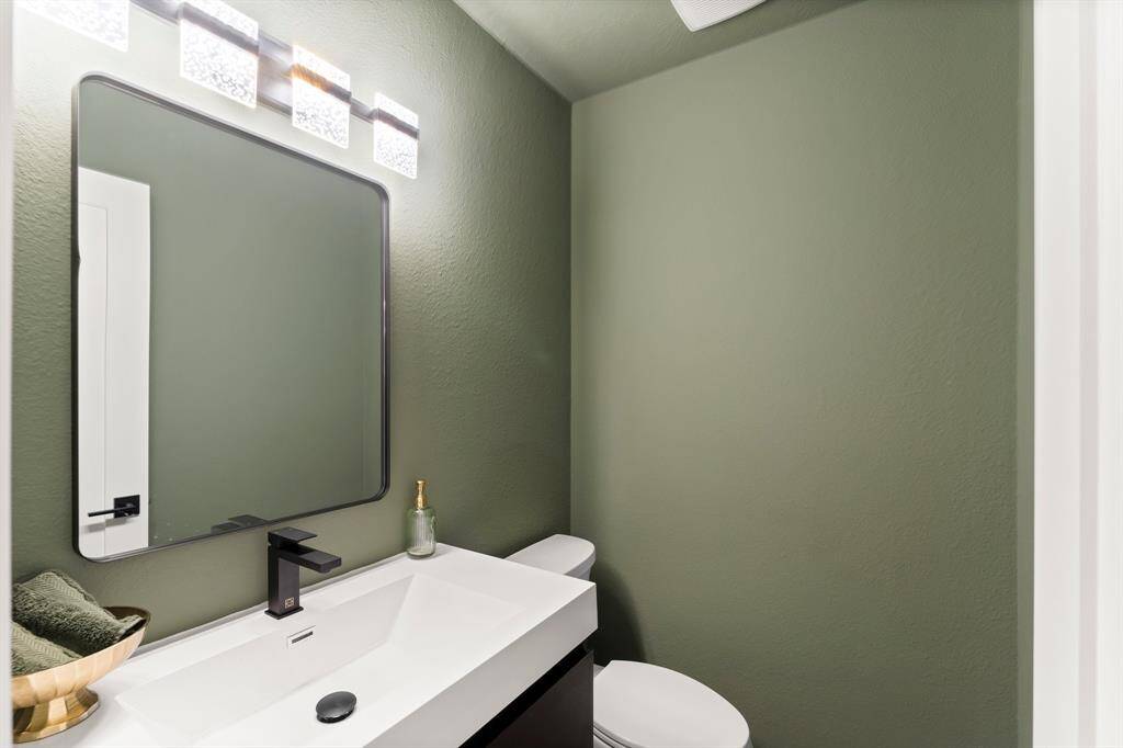 Custom powder bath has a floating vanity with drawers and modern upscale fixtures.