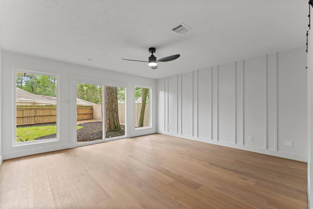 Owner's Suite has authentic white oak wood floors that welcome you into the room. Incredible wall of windows and slider door to a backyard patio, and custom feature wall is eye-catching.