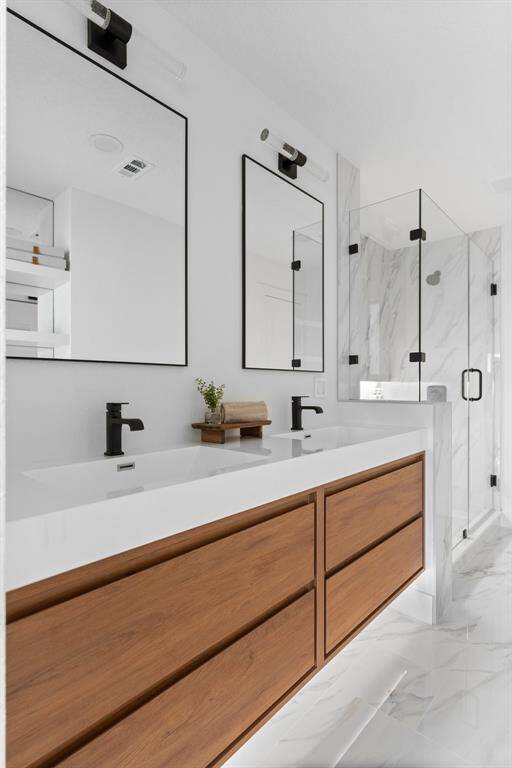 Luxurious, chic, spa-like ambiance is inviting in the primary bathroom. The elegant surroundings make you want to stay. Double vanities with quartz, custom wood vanity drawers offer generous storage as does the recessed shelves/cabinet with mirrored background. Great lighting including under cabinet lighting. Excellent attention to detail, fit and finish.