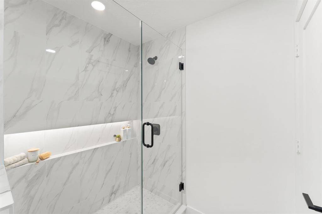 Custom walk-in shower has frameless glass enclosure/door.