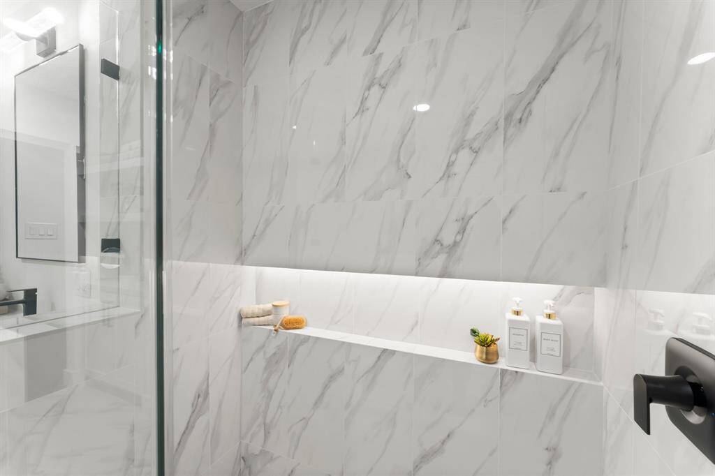 The custom walk-in shower in the primary bathroom is stunning and the well-lit shelf is the new must-have!