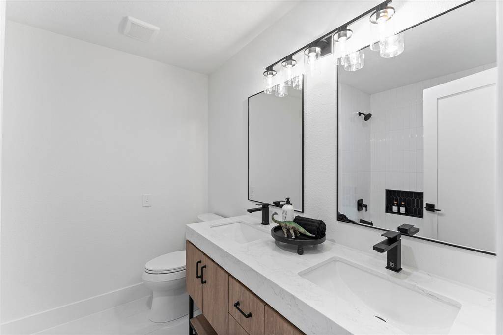 New modern upstairs Bathroom has custom double vanities, new tile floors, new fixtures and lighting.