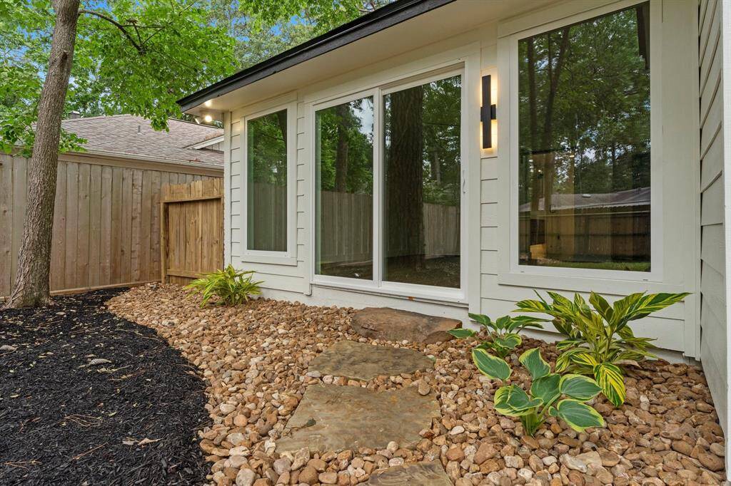 New primary suite has charming rock and stepping stone pathway to backyard and new windows/sliding door.