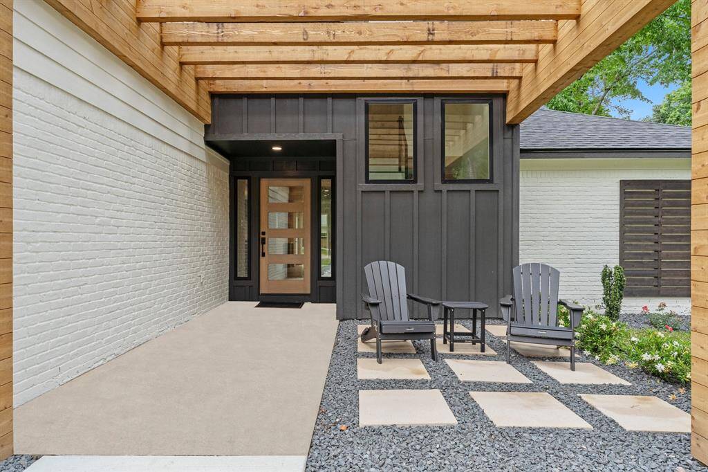 Custom new entry has spectacular front door with sidelites. New windows, with redesigned placement allows views to modern stair design peeking interests. Striking wood structure creates an informal seating area.