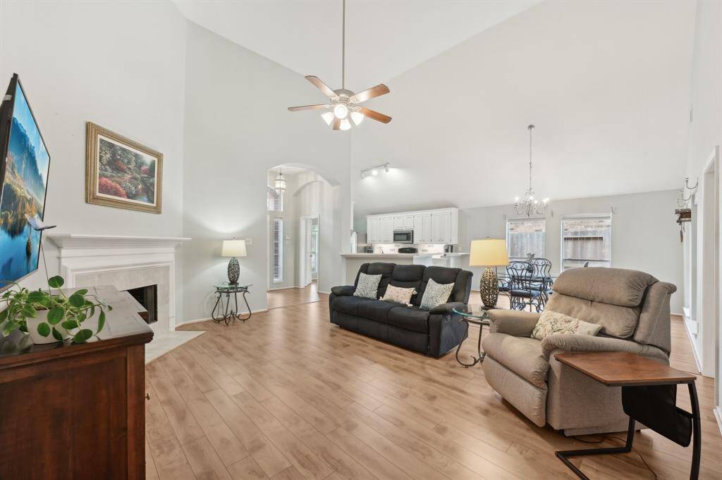 Tall ceilings and bright open living room with corner fireplace.