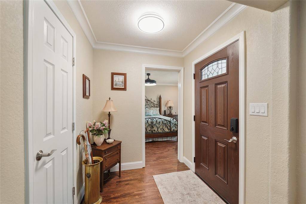 Warm and inviting foyer with wood flooring and crown molding detail, offering a welcoming first impression.