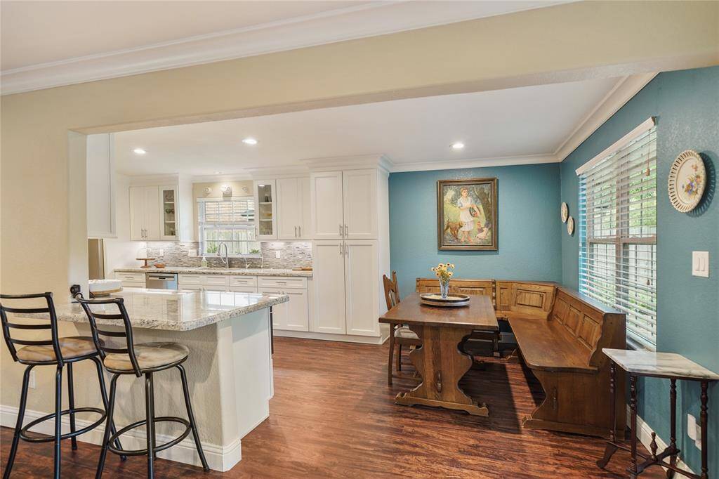 Bright kitchen with granite countertops, pot filler, under-cabinet lighting, and dining nook.