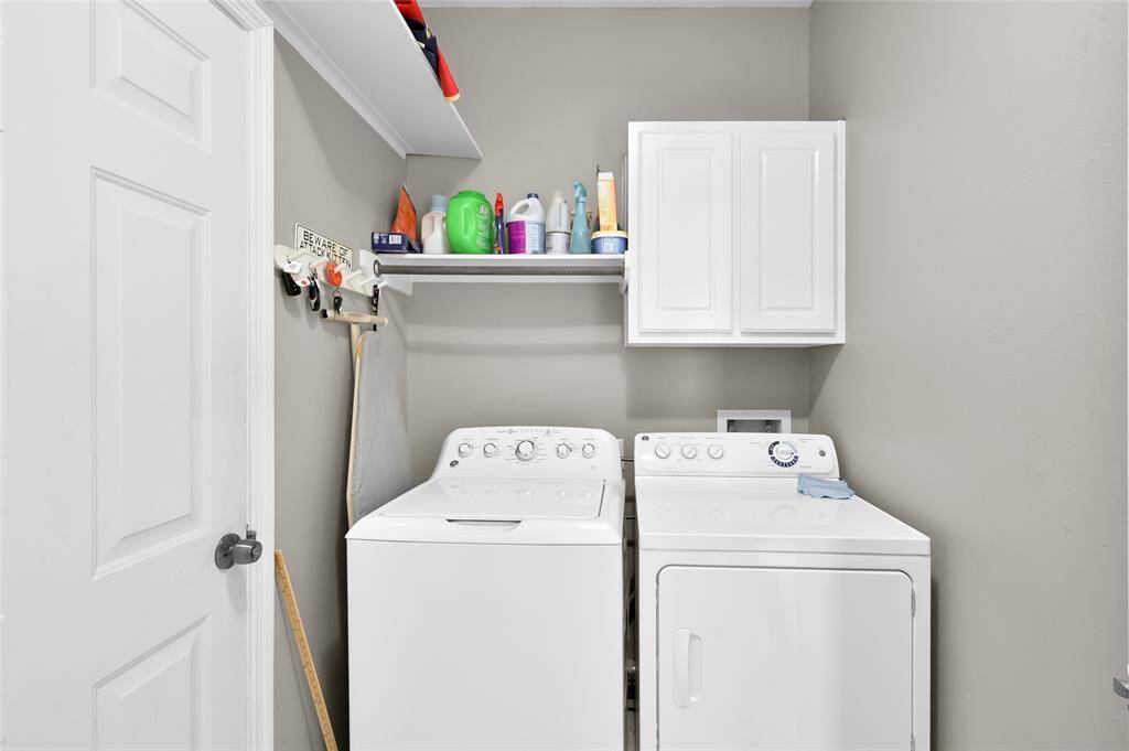 This is a compact laundry room featuring a washer and dryer with a white finish.