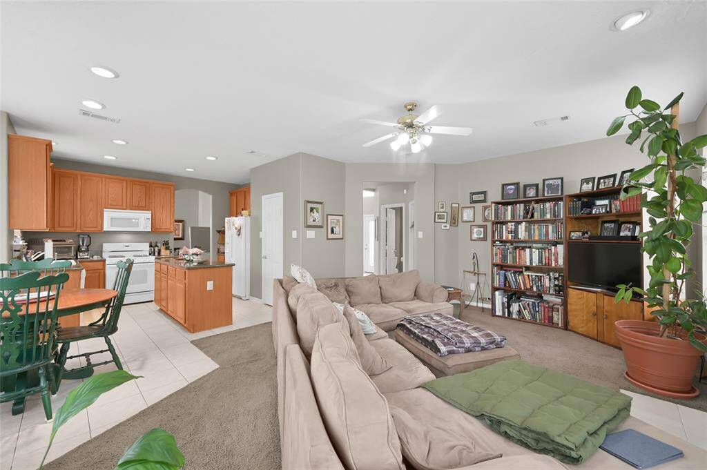 This inviting living space features an open floor plan connecting a cozy carpeted living room.