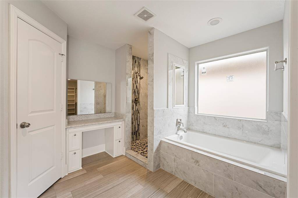 Large primary bath features double vanities, a makeup vanity and spa like shower.