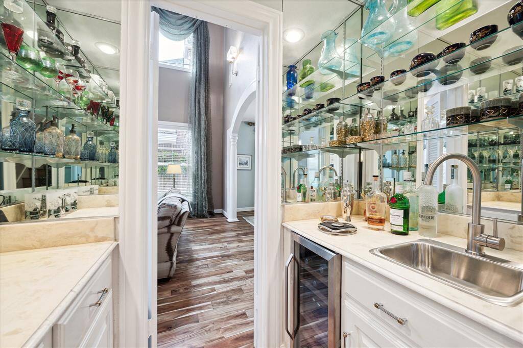 Wet bar with wine chiller and glassed shelving.