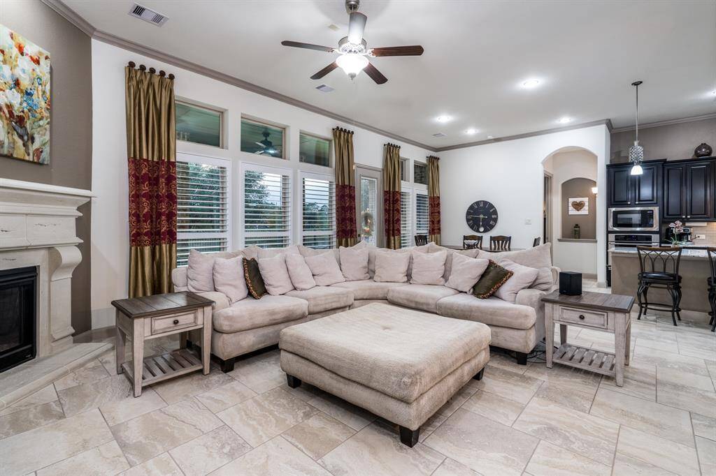 Family room with crown molding, fireplace, ceiling fan, and so much space!