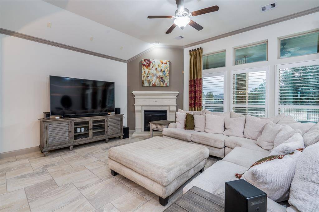 Family room with crown molding, fireplace, ceiling fan, and so much space!