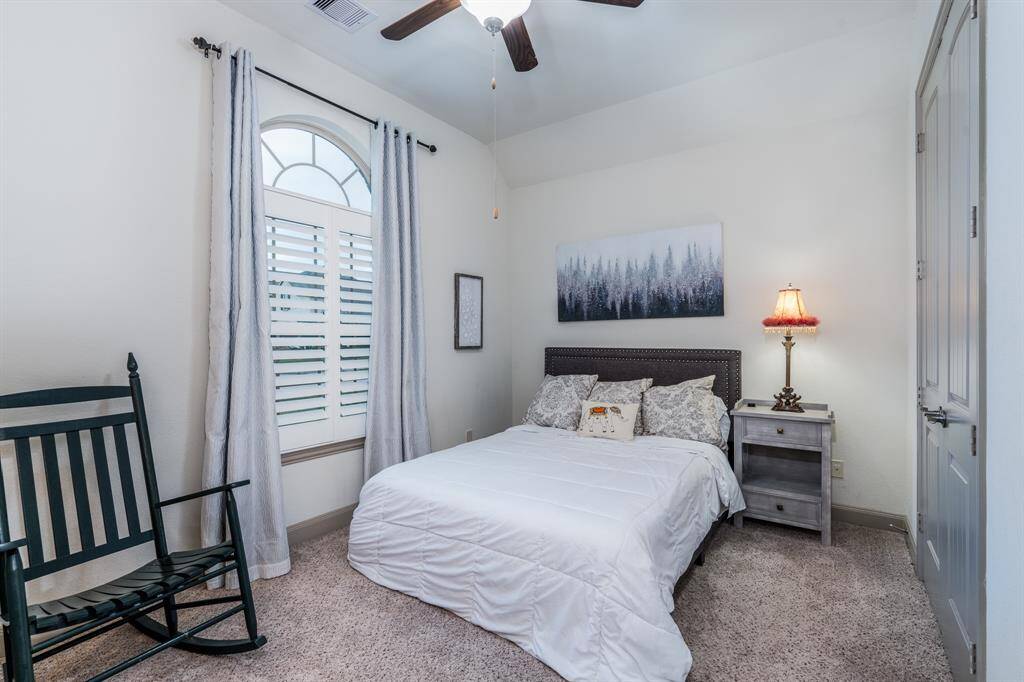Bedroom 2 with plantation shutters, and ceiling fan.