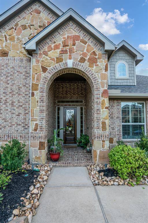 Brick and stone adorn the front, with rock lined flowerbeds and a tall covered porch. The window is the office so you can see out to the front while you're working.