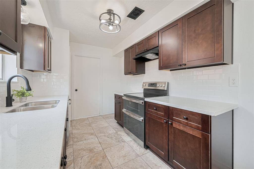 Opposite view of kitchen showing a lot of storage. Access to garage and side door of home .