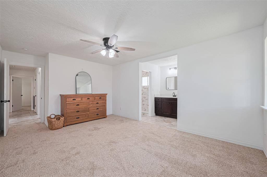 Primary bedroom. situated at back of house, new carpet , paint , ceiling fan .