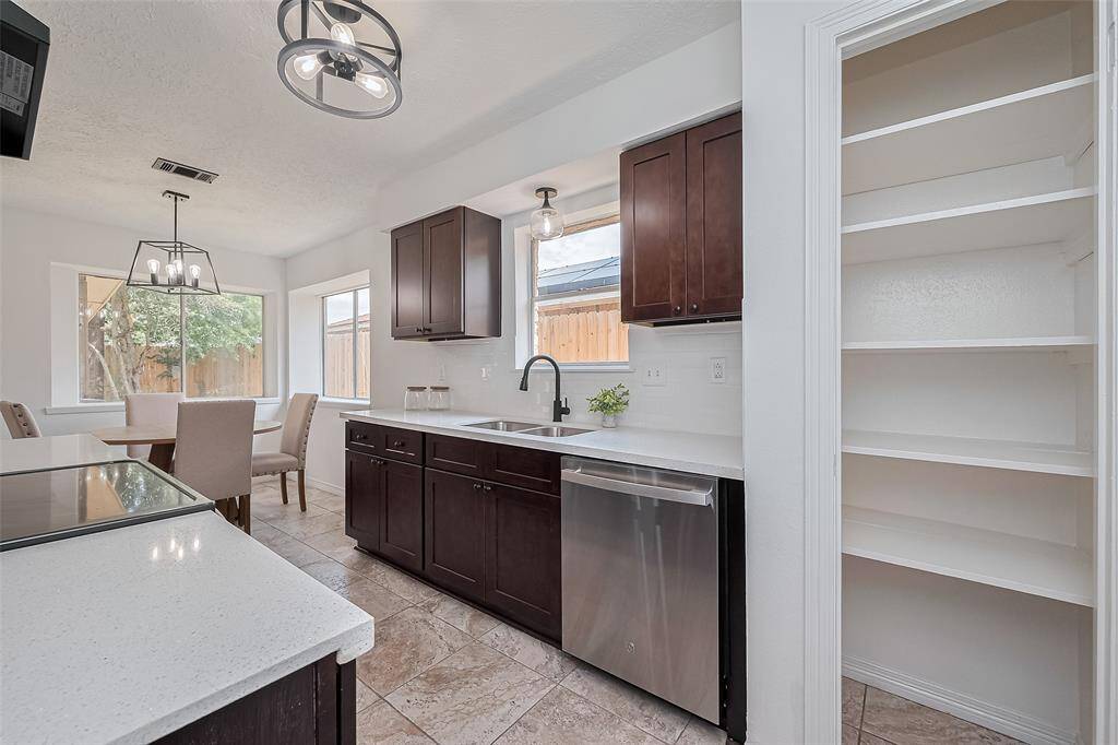 Remodeled kitchen with quartz countertops and dk wood cabinets.