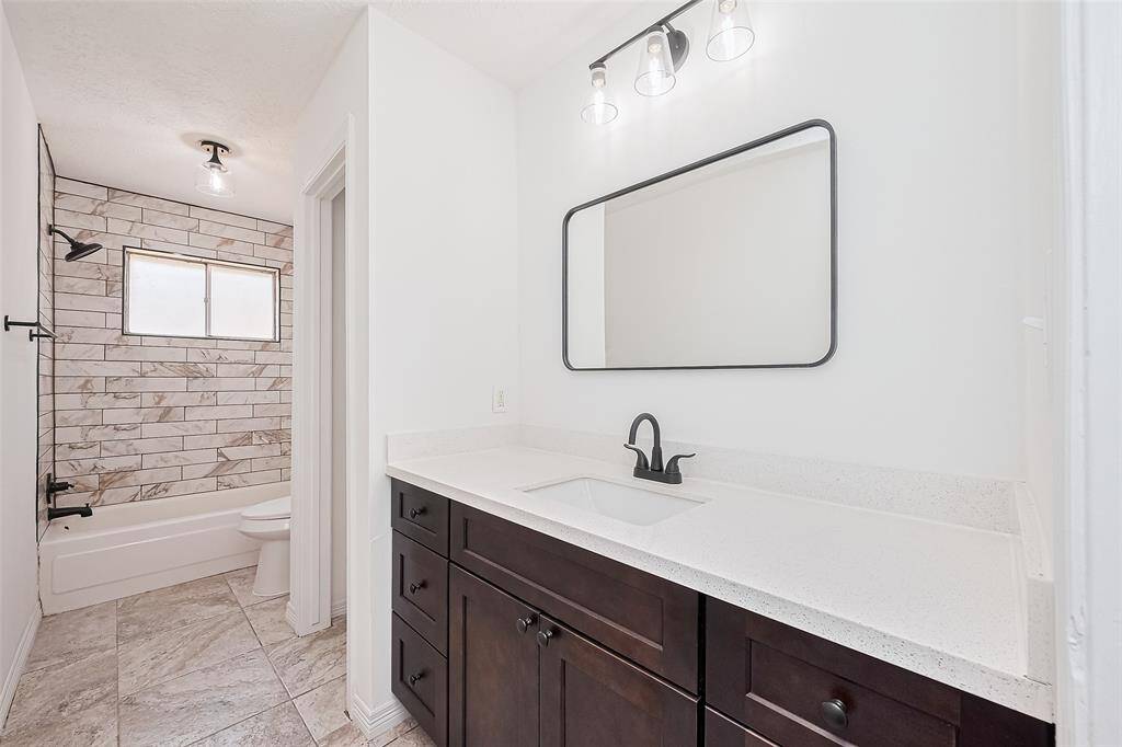 Hall bathroom ,beautifully  remodeled , new counters , cabinets , tile, lighting, mirror and paint .