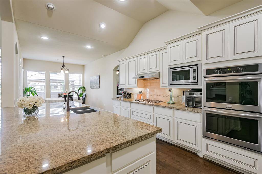 Who would not want to cook in this Kitchen?  Stainless steel appliances include a Farmhouse sink, microwave, dishwasher, double ovens and a 5-burner gas cooktop. Notice the interesting ceiling treatment highlighting this area of the home.