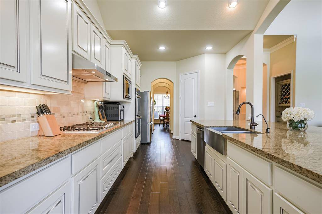 The white cabinets and light colors in the granite pair beautifully with the hardwood floors.  The feel of this room is open and light.  The refrigerator is negotiable.