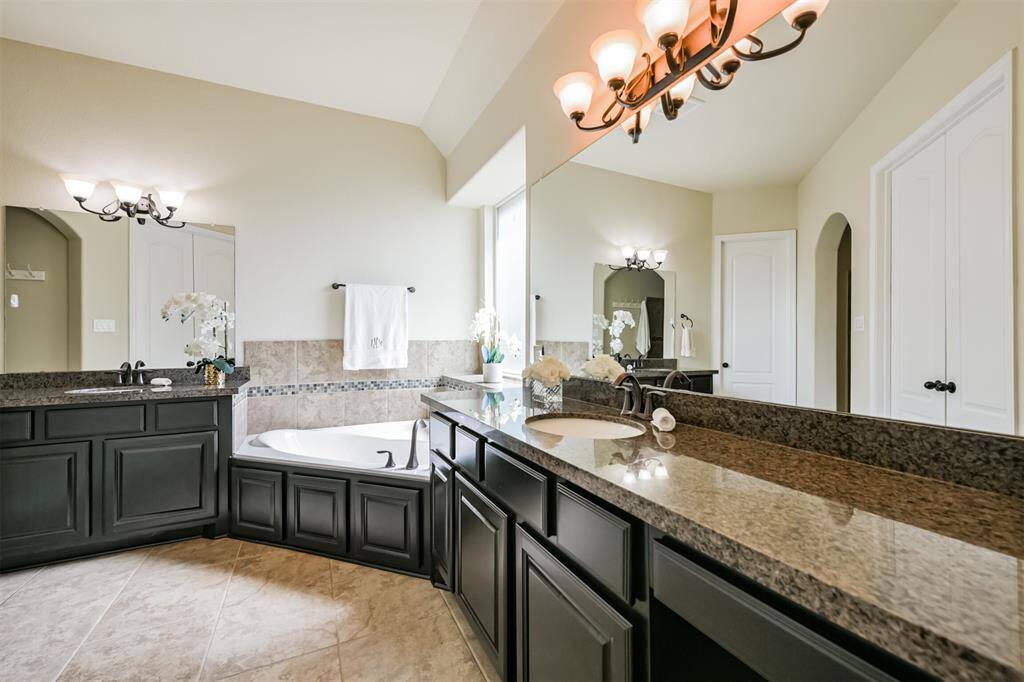 The Primary bath features separate dressing areas, soaking tub and vanity.  There are also two large walk-in closets with builtin drawers and shelving.