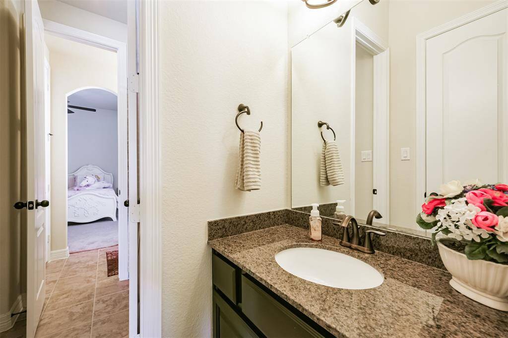 The second section of the Hollywood Bath again with granite counters and under mount  sink.  This area also features tile floors and a walk-in closet. The center area features a tub/shower combination.