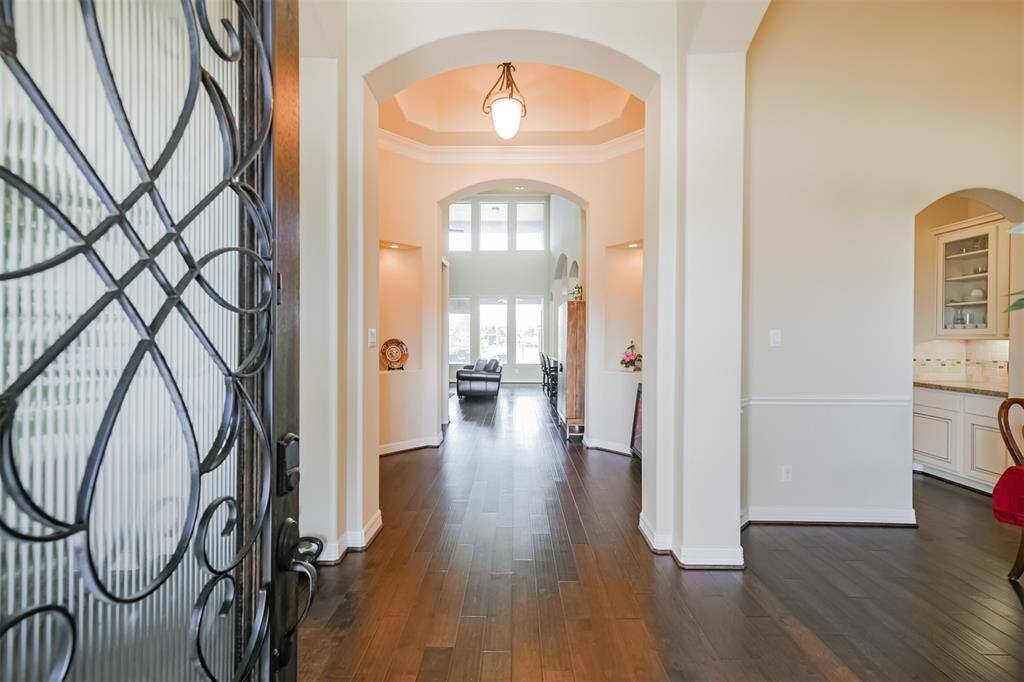 Open the front door and find gleaming hardwood floors, arches, tray ceilings and crown molding in this beautiful Entry and Foyer