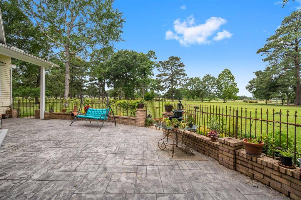 Spacious, stamped concrete patio overlooking a large, lush green yard, perfect for relaxation and outdoor enjoyment.