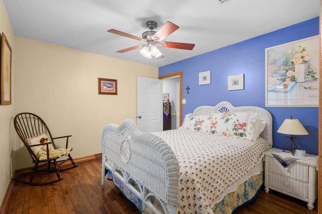 The cozy secondary bedroom with hardwood flooring.