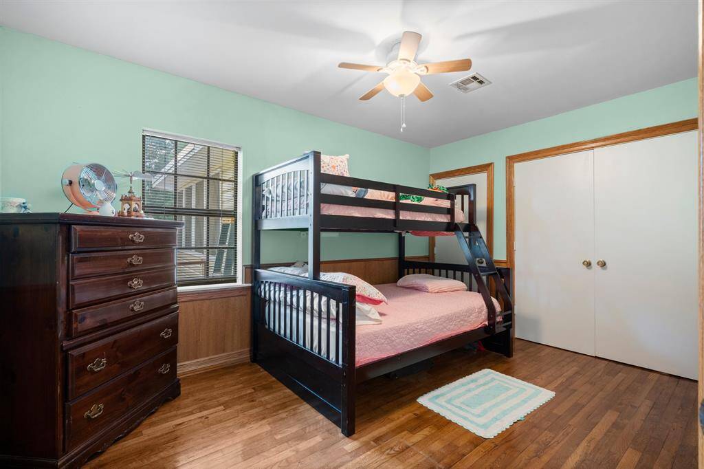 Another bedroom with hardwood flooring and a large closet provides additional storage.