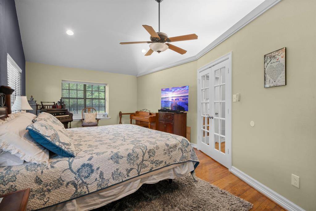 Another view of the primary bedroom showing the french doors to the sitting area or office/study just outside.