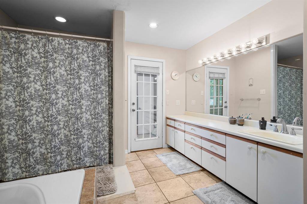 Spacious double vanity with ample storage and a large mirror with bright lighting.