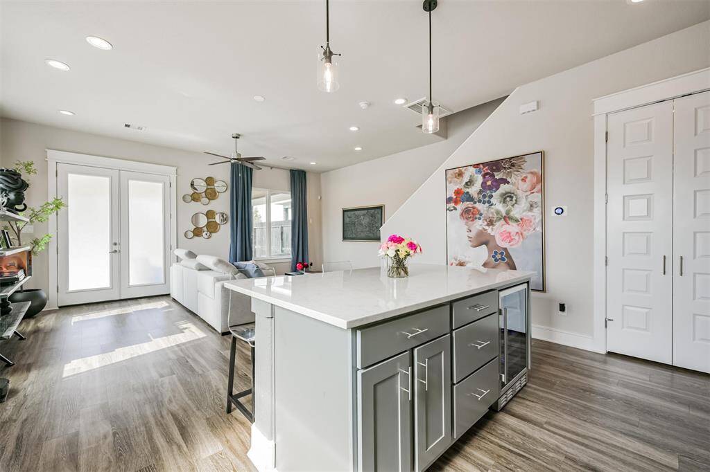 The space is open-concept, flowing into a living area with access to the extended patio through double French doors.