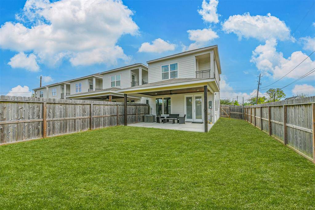 Large backyard features extended covered patio with unobstructed views of the city skyline from second floor balcony.