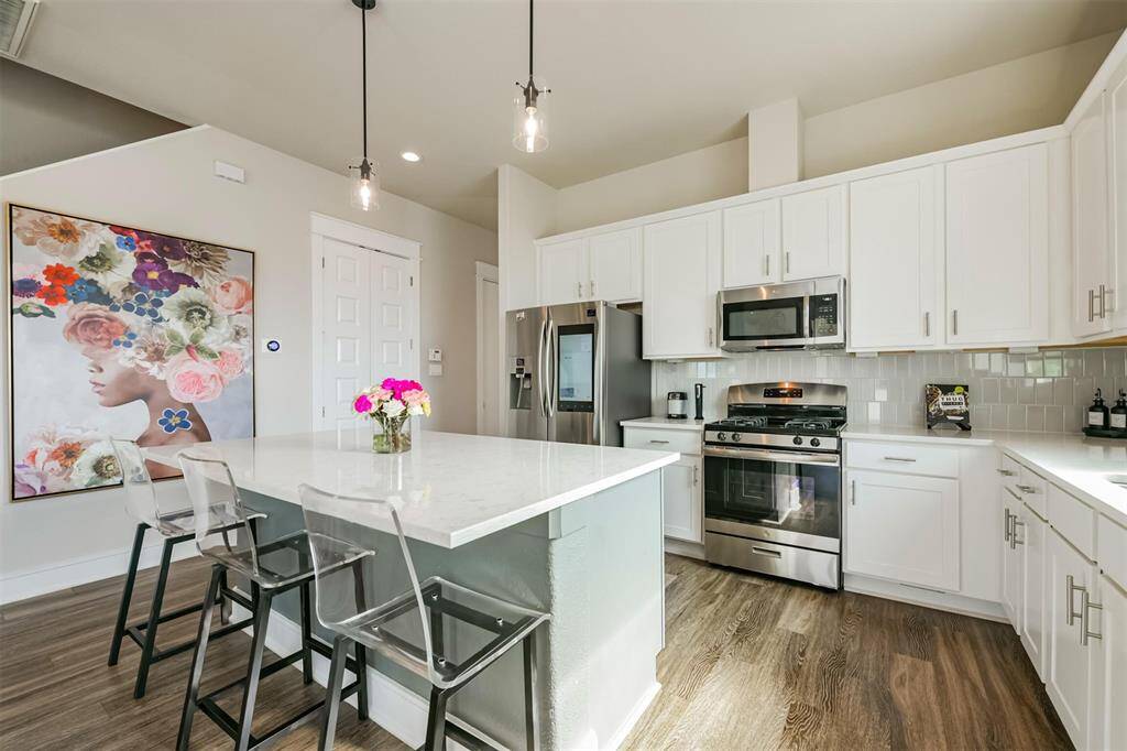 A central island with gleaming quartz countertops makes this space perfect for entertaining.
