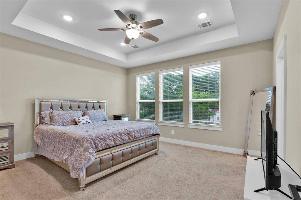 Primary suite featuring a huge walk-in closet and coffered ceilings.