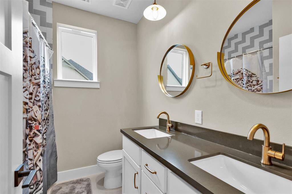 Secondary bathroom with quartz countertops and double sinks.